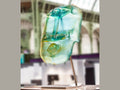 Blue Oil Head sculpture by Romuald Hazoumé, crafted in blue glass by Daum on a metal stand.
