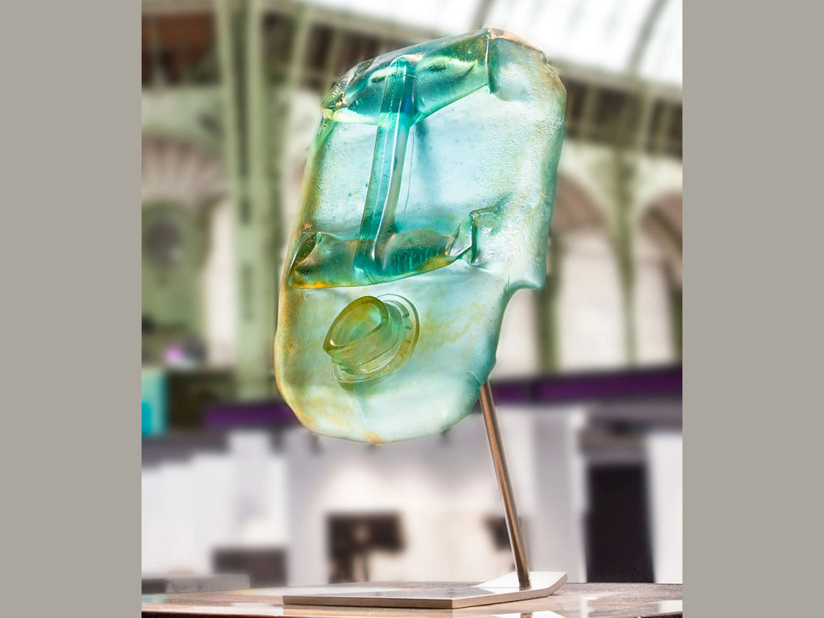 Blue Oil Head sculpture by Romuald Hazoumé, crafted in blue glass by Daum on a metal stand.