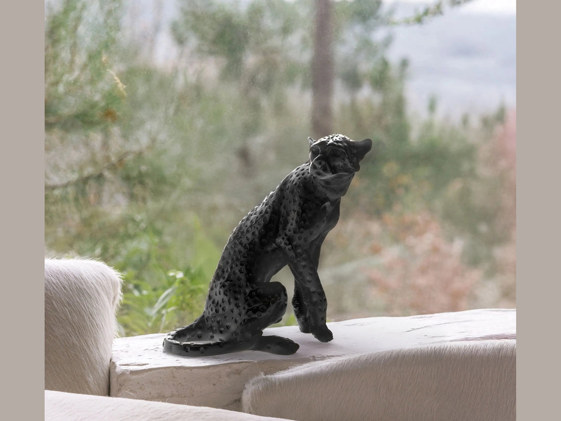 Daum Cheetah Sitting Black sculpture by Jean-François Leroy against a green background