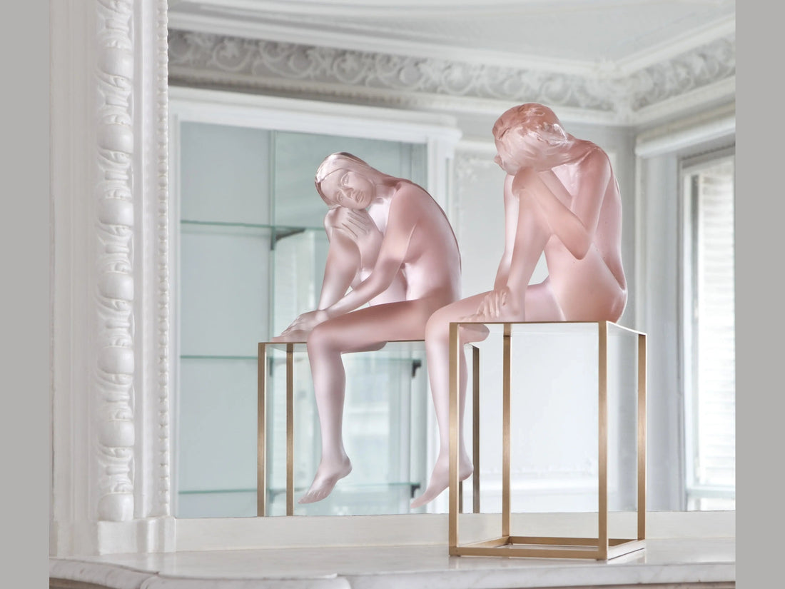 Daum Louison sculpture of a frosted pink glass figure sitting on a gold metal stand
