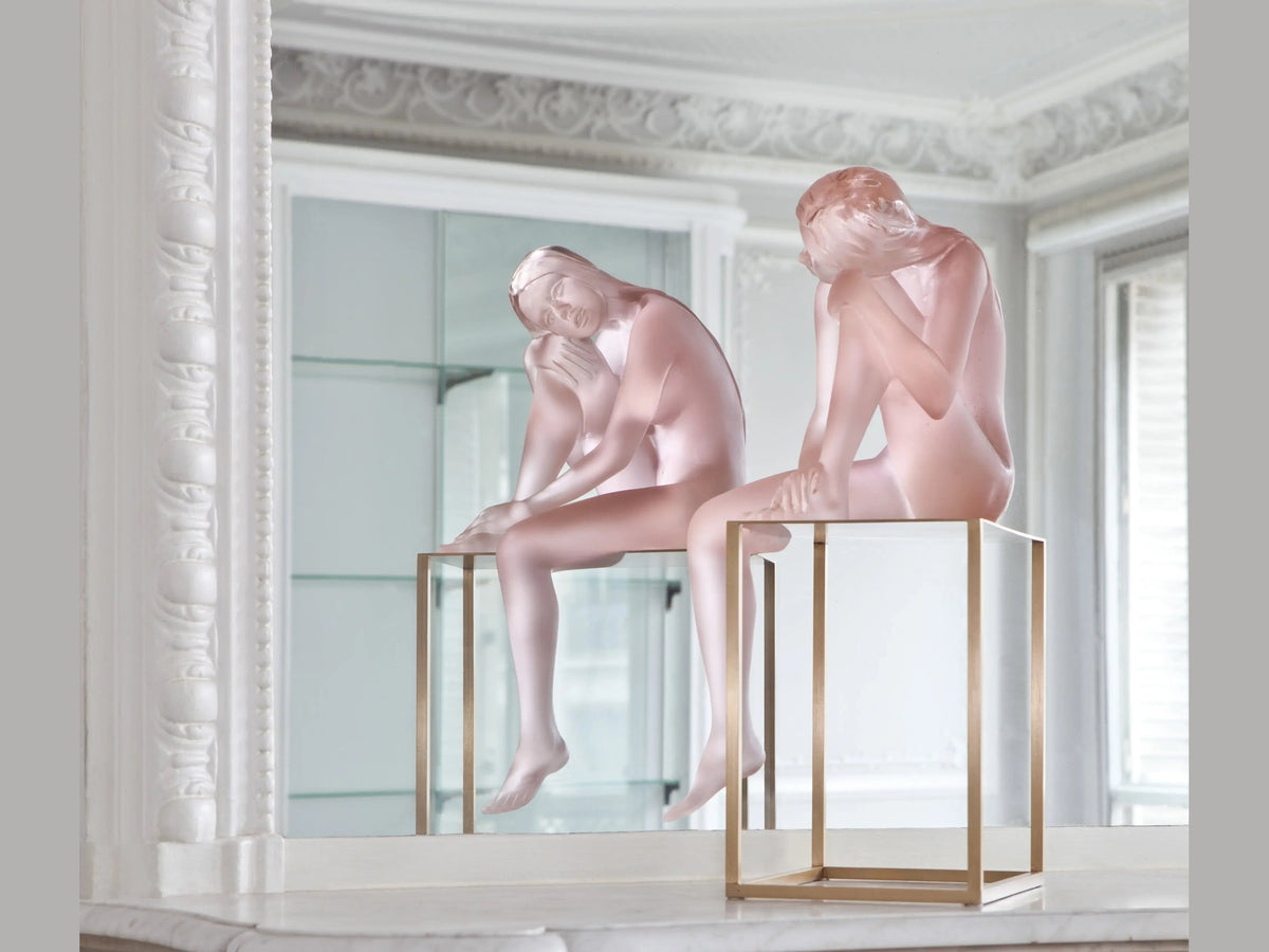 Two frosted glass Louison sculptures by Daum on gold-framed display stands.