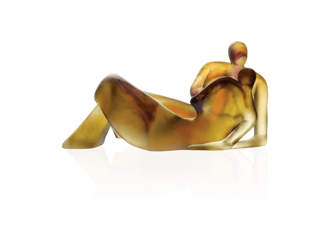 Daum Lune de miel glass sculpture of two embracing figures in amber and gold tones.