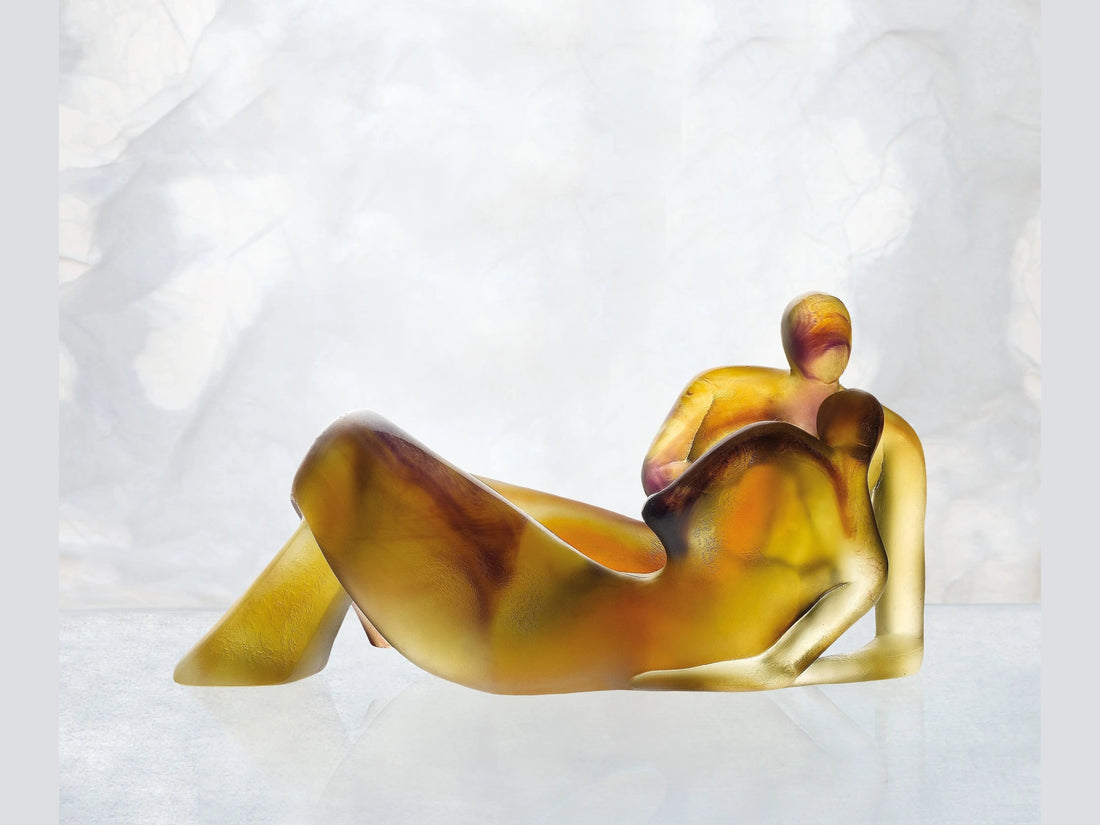 Daum Lune de miel glass sculpture of two embracing figures in amber and gold tones.