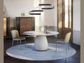 Cattelan Italia BOTERO Keramik Round dining table with modern chairs and sculptural light fixture.