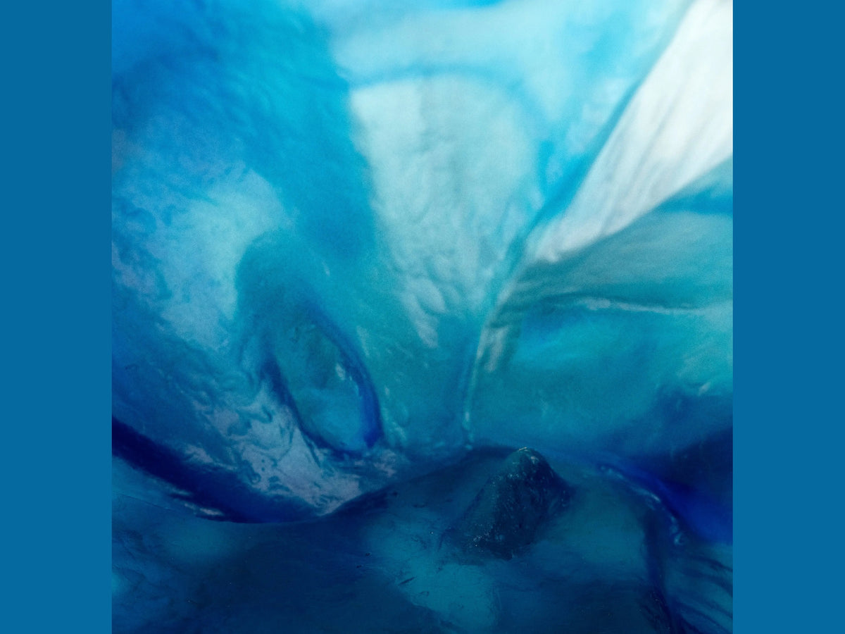 Abstract blue and turquoise swirling patterns of the Daum Maya Coupelle glass art.