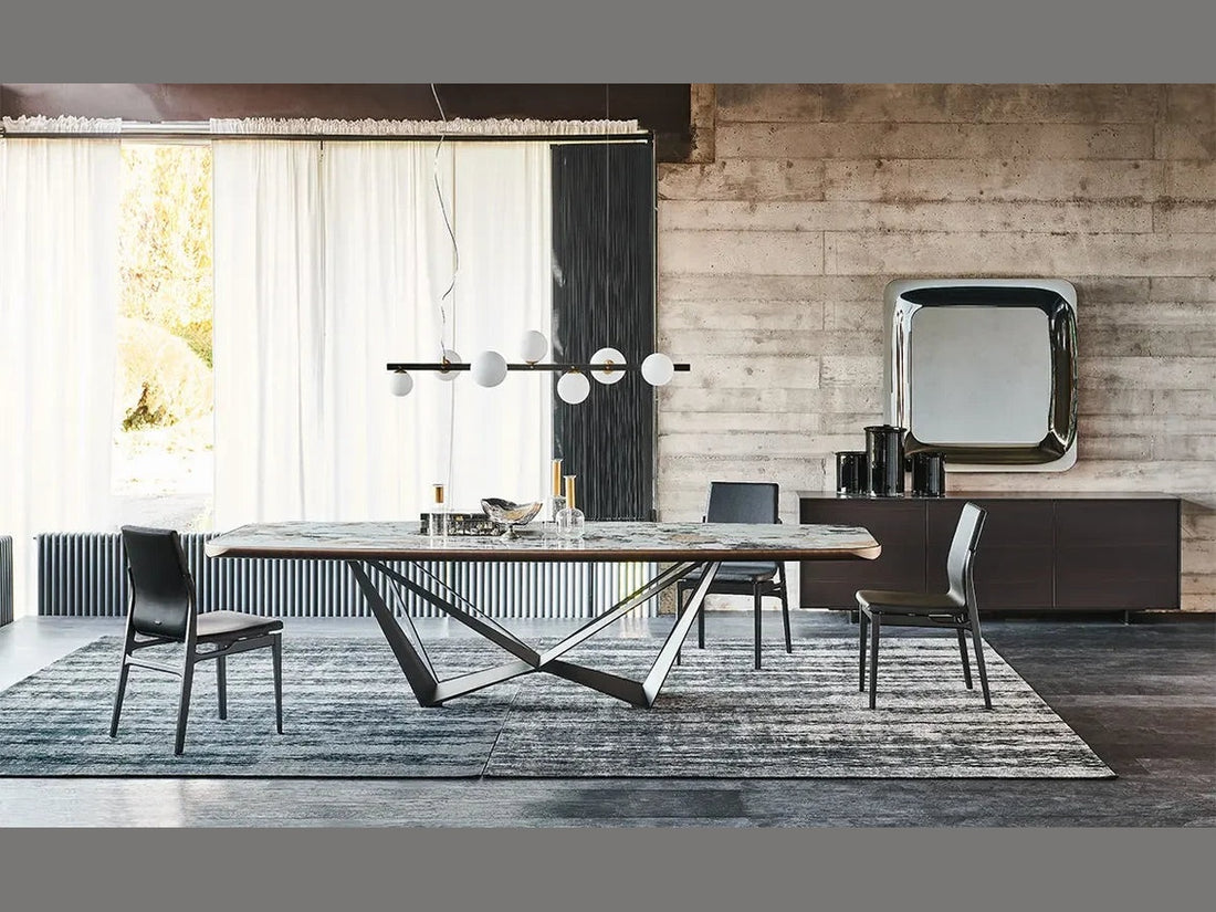 Cattelan Italia Skorpio Keramik dining table with black chairs in a modern industrial interior.