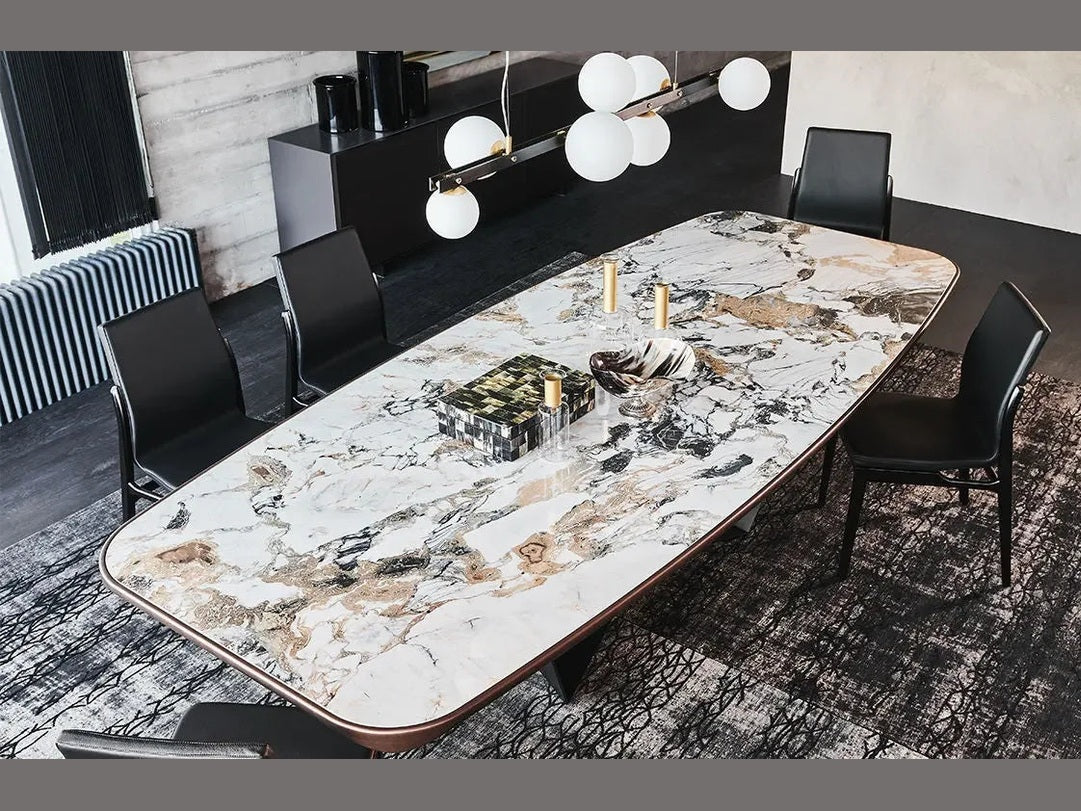 Cattelan Italia Skorpio Keramik dining table with black chairs in a modern industrial interior.