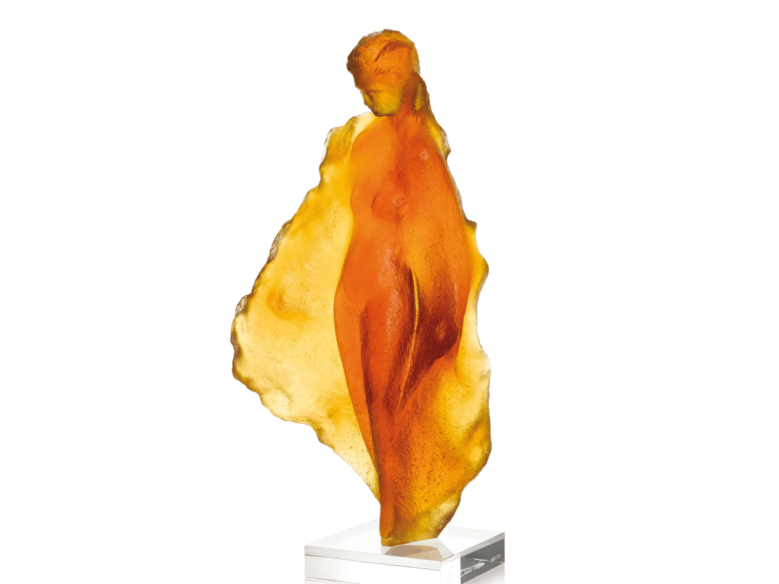 Amber-colored Daum glass sculpture 'Marine' by Michel Coste on a white base against a green background