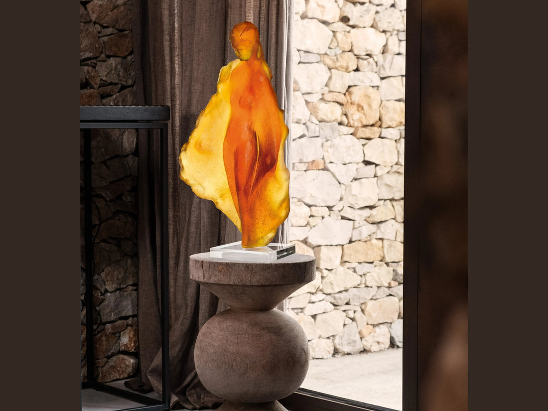 Amber-colored Daum glass sculpture 'Marine' by Michel Coste on a white base against a green background