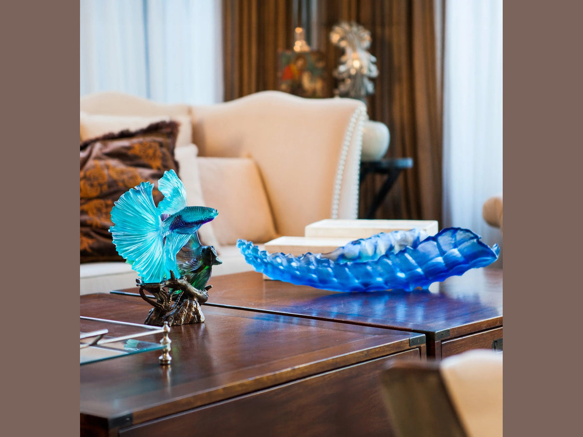 Daum Mer de Corail blue glass centerpiece on a dark wood table