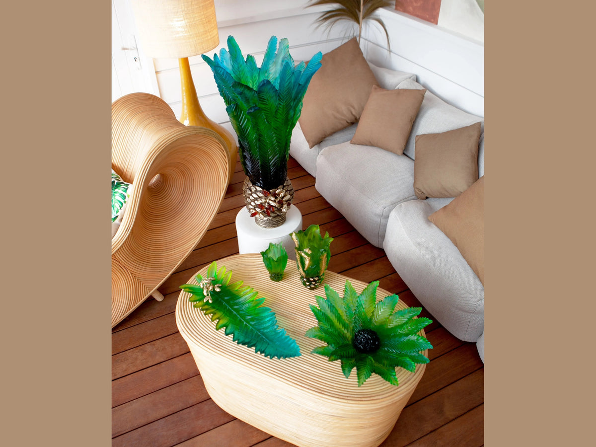 Daum Palm Beach centerpieces in various sizes on a light wood table in a modern living room