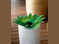 Daum Palm Beach green glass centerpiece on a white textured pedestal