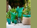 Daum Voyage Tropical teal glass leaf-shaped centerpieces on a textured surface.
