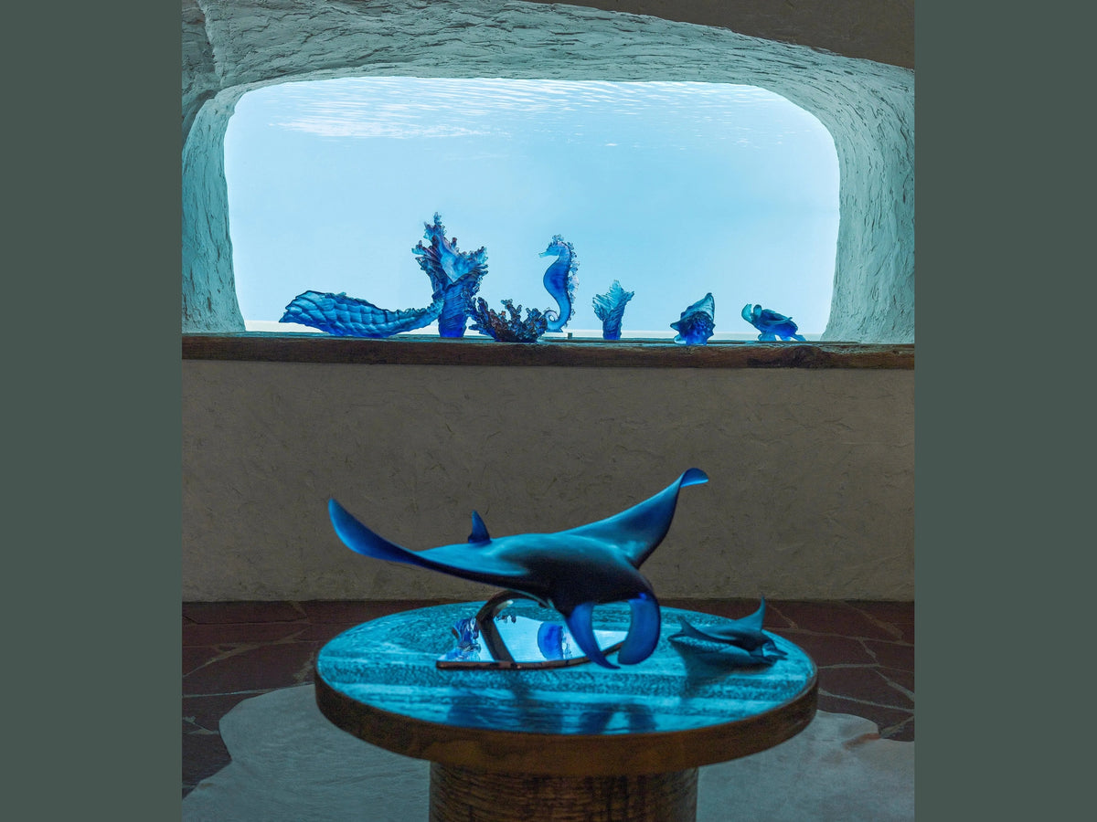 Blue Daum glass manta ray sculpture by Umberto Nuzzo displayed on a table.