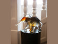 Daum Savannah Elephant glass sculpture by Isabelle Carabantes on a dark pedestal.