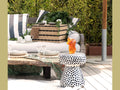 Daum Secret d'amour amber sculpture on a polka dot side table in an outdoor setting