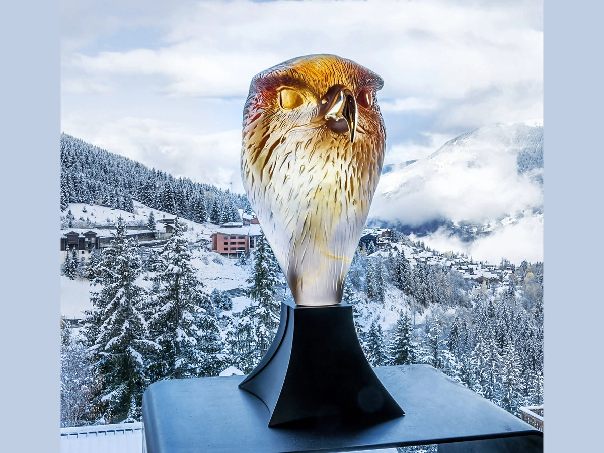 Daum Tête de Faucon glass sculpture by Madeleine Van der Knoop set against a snowy mountain landscape