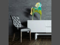 Daum Troya glass horse sculpture on a white sideboard next to a black leather chair