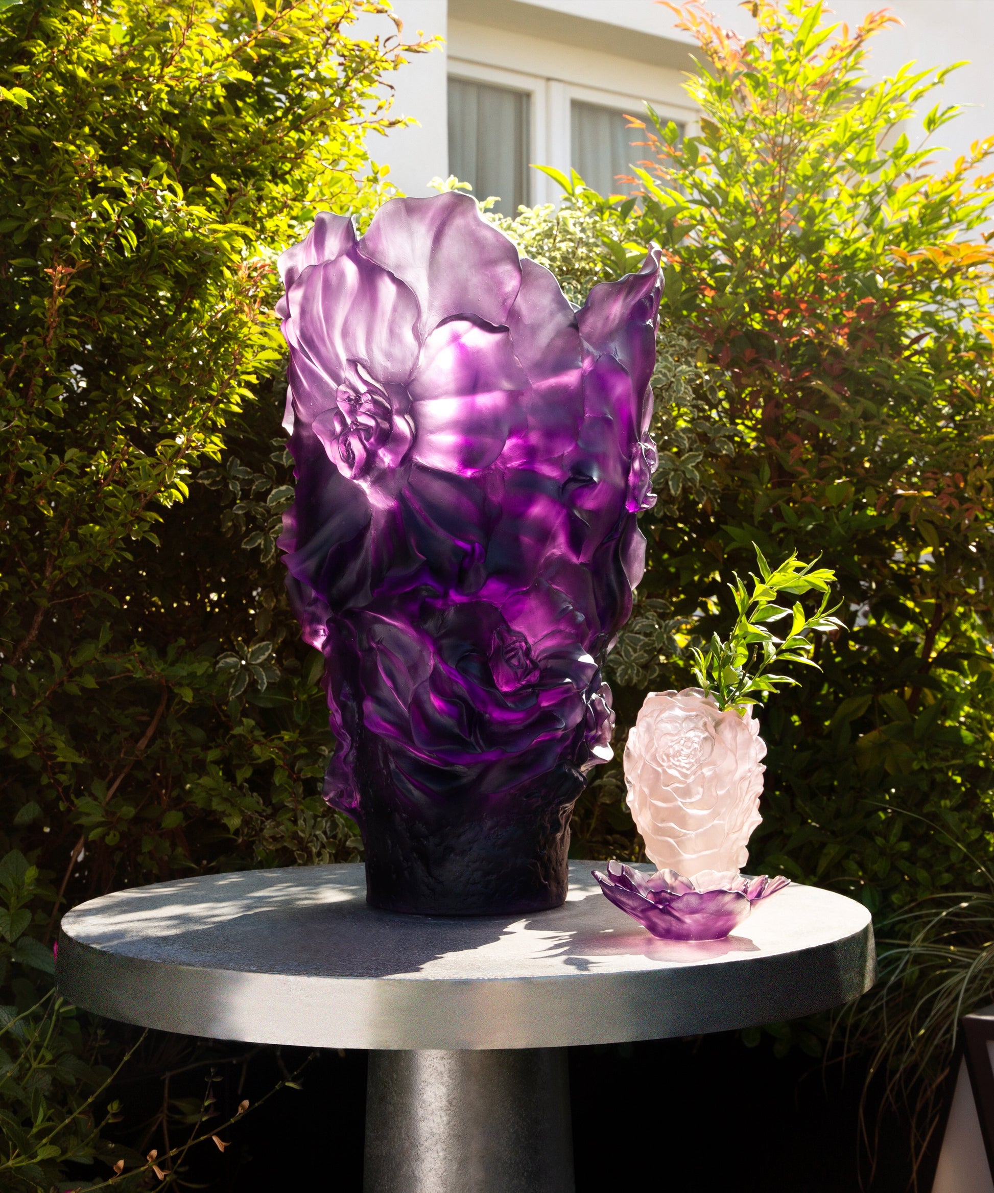 Vase petit modèle Camélia de la marque Daum, en verre transparent avec détails floraux roses.