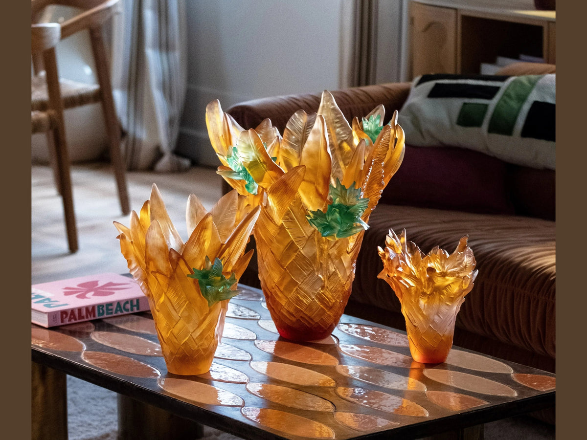 Daum Tressage Paradis amber glass vases with green accents on a reflective surfaceslider_item_NNrJJi