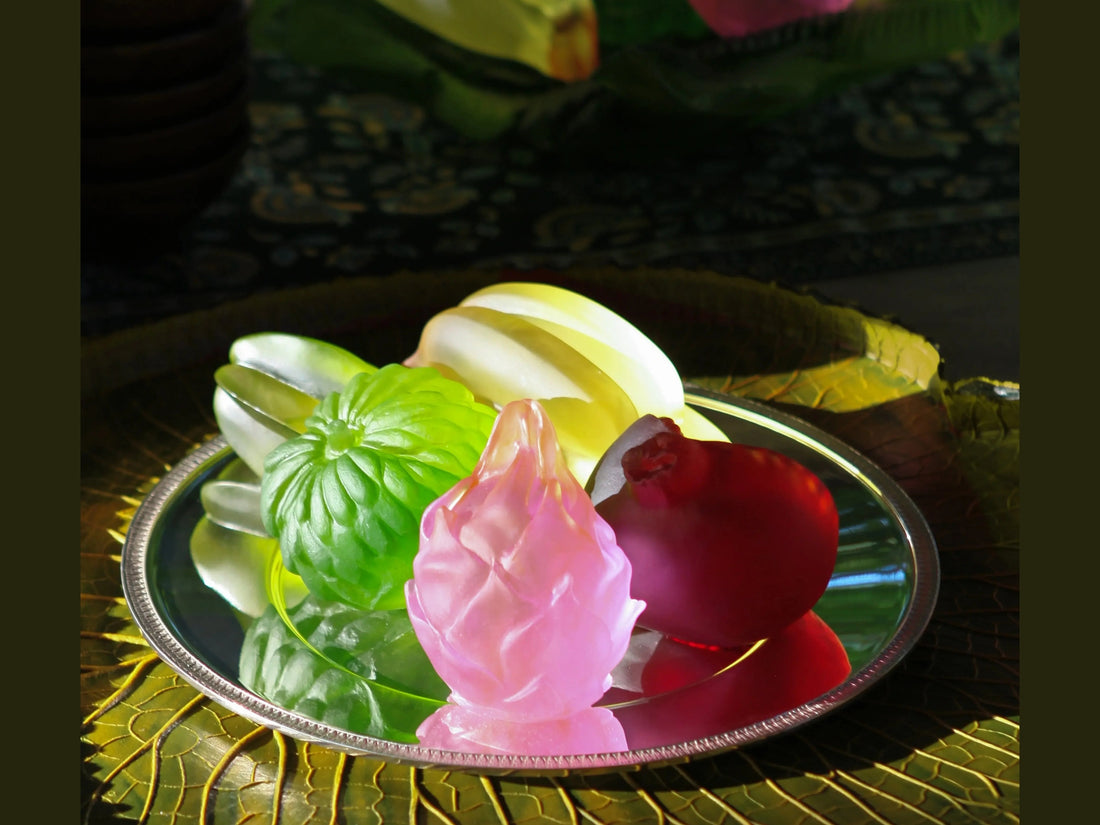 Daum Tutti Frutti dragon fruit sculpture in pink and orange glass on a reflective surface